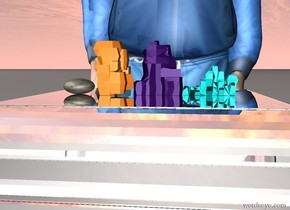 There are 4 rocks on a silver pedestal. There is a tall man behind the pedestal.