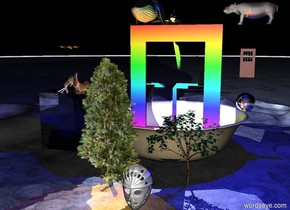 Gigantic rainbow window is in the lake. The lake fits in the bowl. The bowl is 100 feet wide. Whales are above the window. . There is the cube on the left of the bowl. The cube is 40 feet wide.  the cube is transparent.  the elephant fits in the cube. Three gigantic  butterflies are 15 feet above the elephant. The butterflies are facing the window. The big trees are  in front of the bowl. The huge hippo is on the right of the window. The hippo is 85 feet off the ground. The hippo is facing the whales. the door is 15 feet under the hippo. The door is 18 feet tall. The sphere is 12 feet tall. the sphere is 10 feet under the door. The 20 feet tall face mask is in front of the trees. it is night. the green light is on the whales. Blue light is under the hippo. Red light is on the bowl. The yellow green light is on the left of the sphere. The violet light is above the whales. The orange light is in the cube. The sphere is silver
