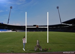 The cannon is 15 feet in front of the goal. The cannon is facing the goal. The cannon and goal are in the stadium. The large football is 7 feet in front of the goal and 10 feet above the ground.  A second football is 1 feet to the right of the cannon. the third football is 1 foot to the right of the second football.A man is 3 feet to the left of the cannon. The man is facing southeast.